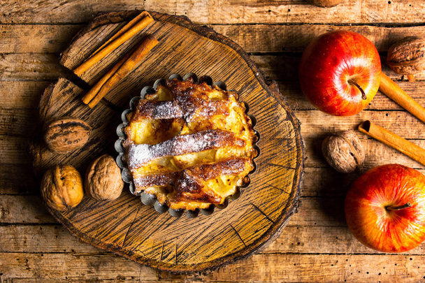 Домашний яблочный пирог с корицей на столе
 - Фото, изображение