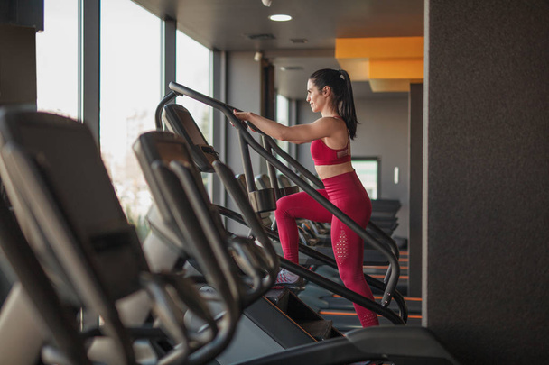 Woman training on exercise machine - Фото, зображення