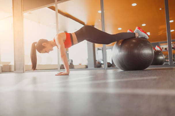 Woman performing plank on exercise ball - Foto, imagen