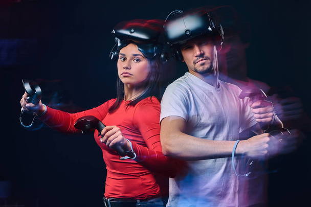 Nuoren valkoihoisen parin muotokuva, joka poseeraa VR-kuulokkeiden ja ohjainten kanssa
. - Valokuva, kuva