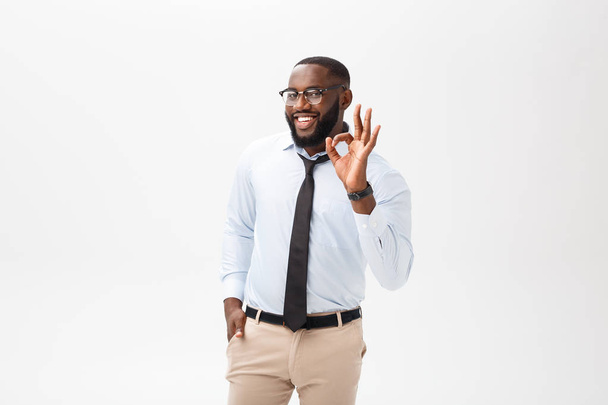 Homem de negócios preto jovem que tem olhar feliz, sorrindo, gesticulando, mostrando sinal OK. Homem africano a mostrar um gesto de OK com os dedos. Conceito de linguagem corporal
. - Foto, Imagem