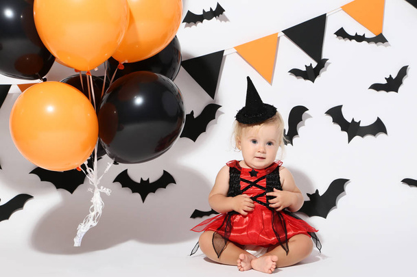 Baby girl in halloween costume and balloons on white background - Foto, Imagen