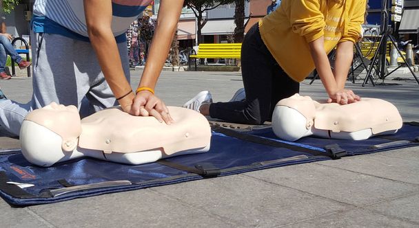 Люди вчаться робити першу допомогу при стисканні серця
 - Фото, зображення