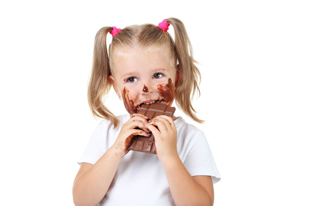 Menina feliz comendo chocolate no fundo branco
 - Foto, Imagem