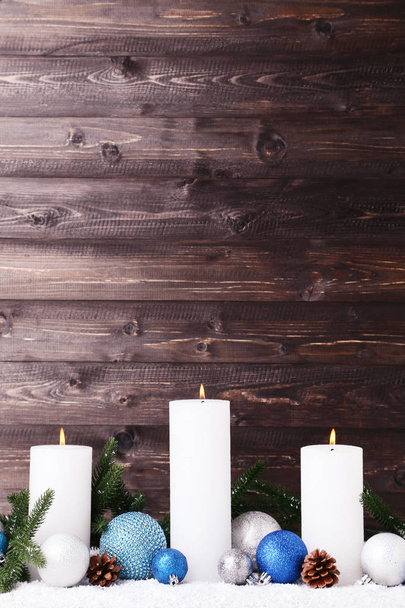 White christmas candles with baubles and cones on wooden background - Photo, image