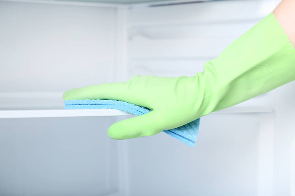 Hand in glove with sponge cleaning refrigerator - Foto, immagini