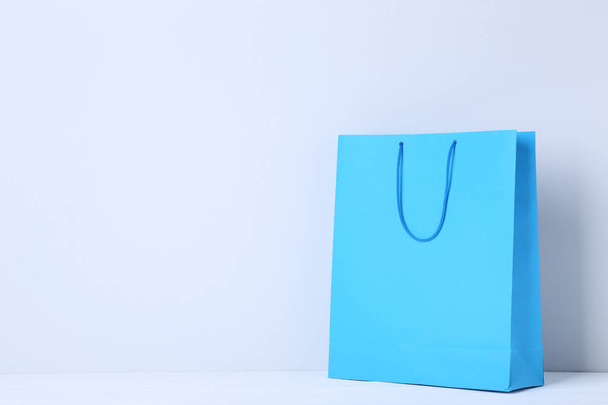 Blue shopping bag on grey background - Foto, afbeelding