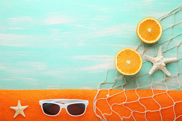 Summer accessories with starfishes and orange fruit on wooden table - Zdjęcie, obraz