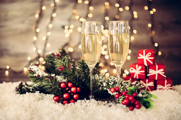 Vánoční dekorace se dvěma sklenkami šampaňského a světla na dřevěné pozadí, šťastný nový rok. Oslava. Selektivní fokus a malá hloubka ostrosti. - Fotografie, Obrázek