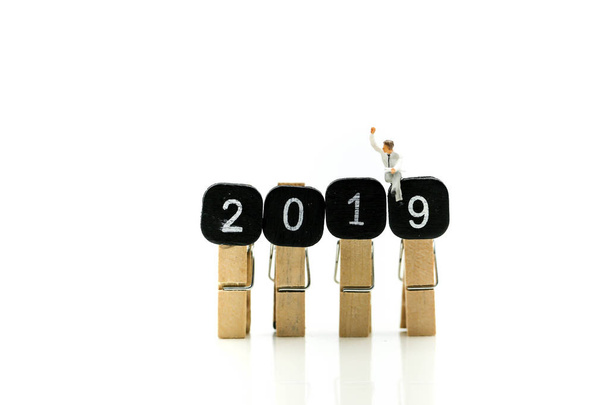 Miniature people : sitting with Clothespins of word 2019 Education and business design concept  using for  coming New Year 2019. - Φωτογραφία, εικόνα