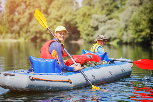 Happy kids kayaking on the river on a sunny day during summer vacation - Valokuva, kuva