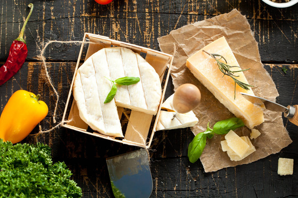 Pieces of parmigiano reggiano or parmesan cheese on wood board - Fotografie, Obrázek