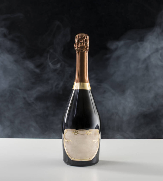 Champagne Bottle on a table with smoke in the background - Zdjęcie, obraz