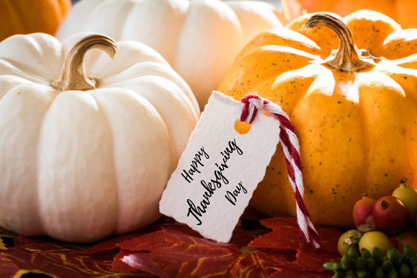 Díkůvzdání blahopřání s rukopisem "Happy Thanksgiving Day". Podzimní javorové listy a dýně na staré dřevěné pozadí. Den díkůvzdání koncept. - Fotografie, Obrázek