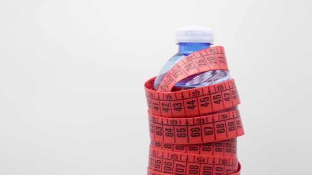 μπουκάλι νερού και κόκκινη ταινία μέτρησης με χώρο αντιγραφής, όπως η έννοια του τρόπου ζωής και της δίαιτας  - Πλάνα, βίντεο