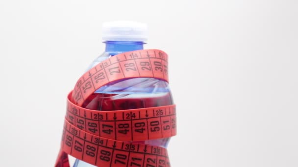 fles water en rode meetlint met Kopieer ruimte, zoals concept van levensstijl en dieet  - Video