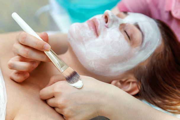 spa, resort, beleza e conceito de saúde - mulher bonita no salão de spa recebendo tratamento facial - Foto, Imagem