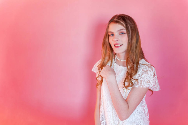 Happy teenage girl smiling. Closeup portrait young happy positive woman wearing white dress standing on pink colourful pastel trendy modern fashion pin-up background. European woman. Positive human emotion facial expression body language - Foto, imagen