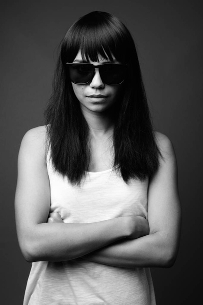 Young Asian woman against gray background in black and white - Foto, immagini