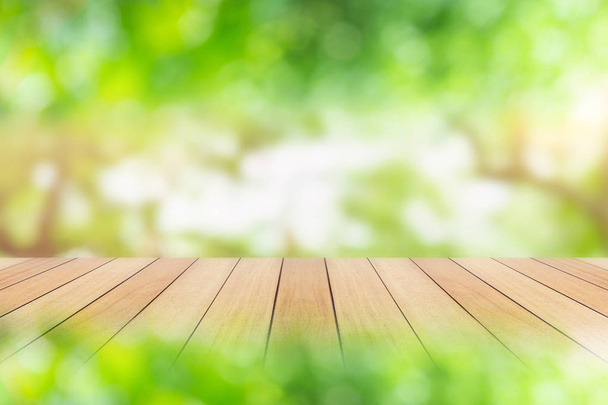 Порожня дерев'яна дошка або стіл і абстрактний зелений розмитий фон. Вільний простір може бути використаний для фотомонтажу або дизайну дисплея продукту та реклами
 - Фото, зображення