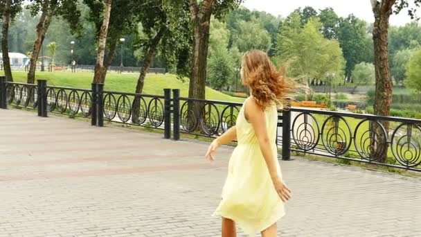 Young happy long-hair  girl  in yellow dress dance on city street. Slow motion  city scene,  - Materiał filmowy, wideo