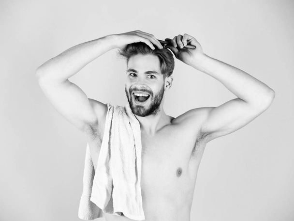 Handsome young happy man combing his hair - Фото, зображення