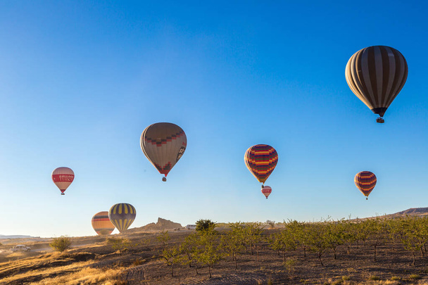 CAPPADOCIA, TURKEY - JULY 29, 2017: Hot air Balloons flight in Cappadocia, Nevsehir, Turkey in a beautiful summer day - Fotó, kép