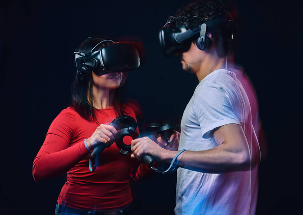 Giovani coppie che giocano ai videogiochi indossando occhiali di realtà virtuale con controller
. - Foto, immagini