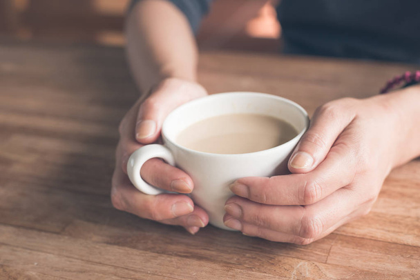 femme tenir une tasse un café à la maison - Photo, image