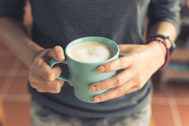 femme tenir une tasse un café à la maison - Photo, image