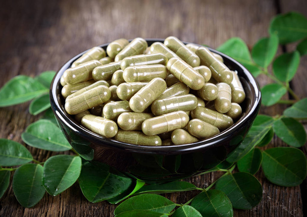 Moringa bladeren en capsules (Kruiden voor de gezondheid) - Foto, afbeelding