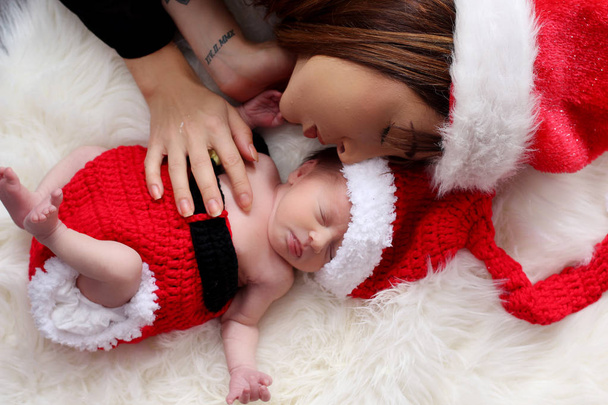 família feliz mãe e bebê em chapéus de Natal vermelho
 - Foto, Imagem