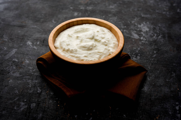 Tavallinen juustomassa tai jogurtti tai Dahi hindi, tarjoillaan kulhoon oikukas tausta. Valikoiva painopiste
 - Valokuva, kuva