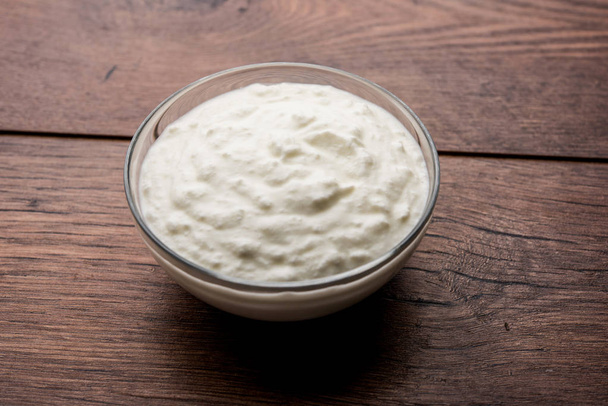 Tavallinen juustomassa tai jogurtti tai Dahi hindi, tarjoillaan kulhoon oikukas tausta. Valikoiva painopiste
 - Valokuva, kuva