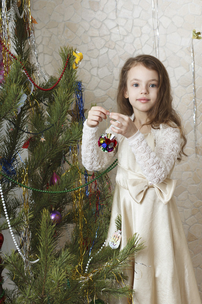 όμορφο κορίτσι στολίζει το χριστουγεννιάτικο δέντρο. - Φωτογραφία, εικόνα
