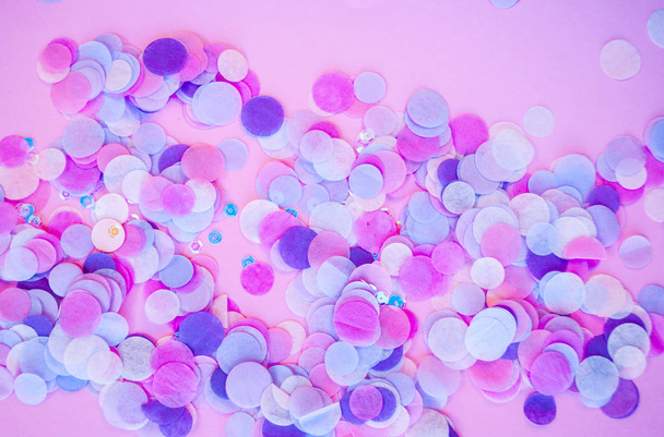 Flat lay of multicolored confetti and sparkles on pink background. - Фото, зображення
