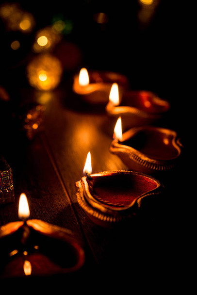 Diwali diya ou iluminação à noite com presentes, flores sobre fundo mal-humorado. Foco seletivo
 - Foto, Imagem