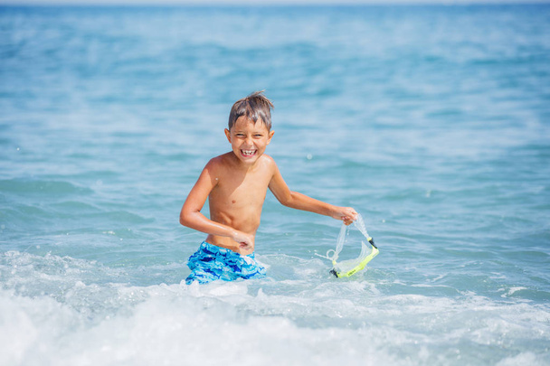 Boy having fun on tropical beach on suuny day - Valokuva, kuva