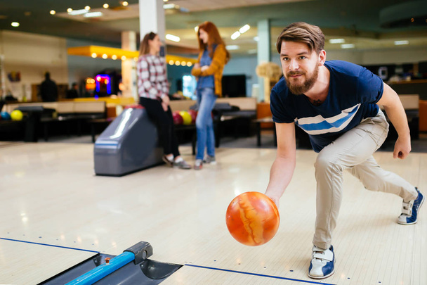 Happy friends having fun and enjoying playing bowling together - Foto, Bild