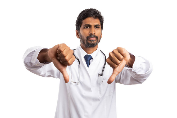 Разочарованный практикующий мужчина или медик, держащий два больших пальца вниз, как неприязненный жест, изолированный на белом фоне
 - Фото, изображение