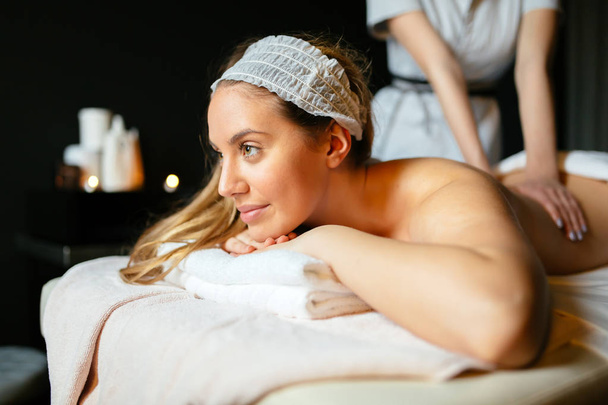 Lovely brunette enjoying massage treatment by therapist - Фото, зображення