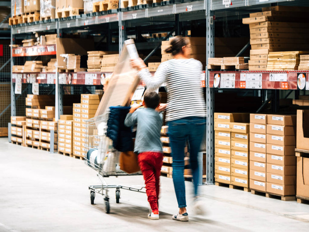 Alleinerziehende Mutter beim Einkaufen im Möbelhaus Ikea schiebt Einkaufswagen - Foto, Bild