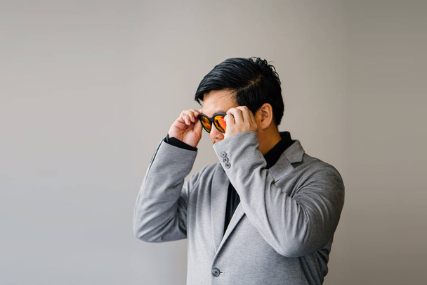 portrait of a Chinese Asian man in a grey suit, black shirt and sunglasses (smart casual). He is confident, cool and handsome in his smart casual outfit  - Фото, зображення