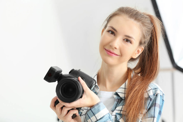 Young female photographer working in studio - Фото, зображення