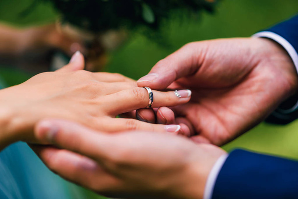 sposo mette sposa una fede nuziale d'oro sul dito
 - Foto, immagini