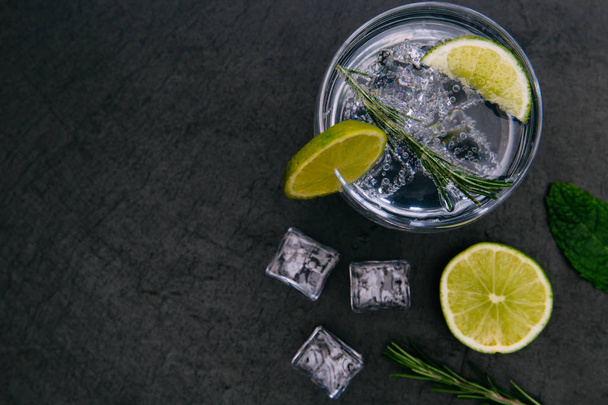 Gin tonic cocktail drink con vetro di ghiaccio calce verde su sfondo scuro
 - Foto, immagini