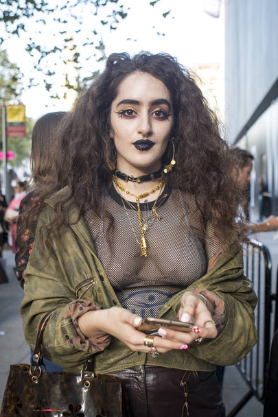LONDON, UK- SEPTEMBER 14 2018: People on the street during the London Fashion Week. Girl in a black transparent mesh blouse and a bomber jacket with black lips - Photo, Image