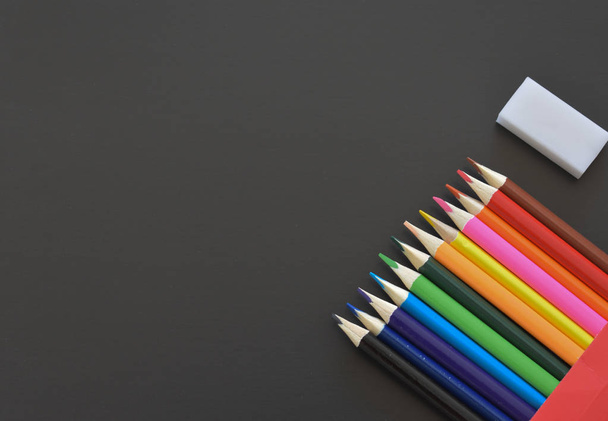 Bright colored pencils on a black background - Foto, Imagen