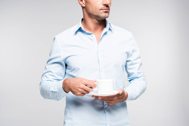 обрезанный снимок красивого взрослого мужчины с чашкой кофе, изолированной на белом
 - Фото, изображение