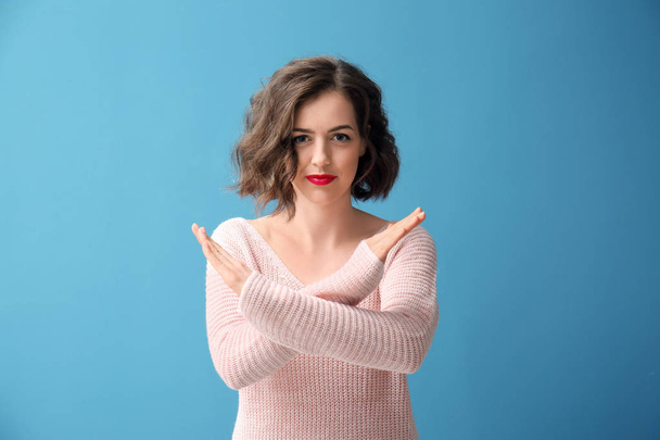 Portrait of beautiful woman showing STOP gesture on color background - Photo, Image